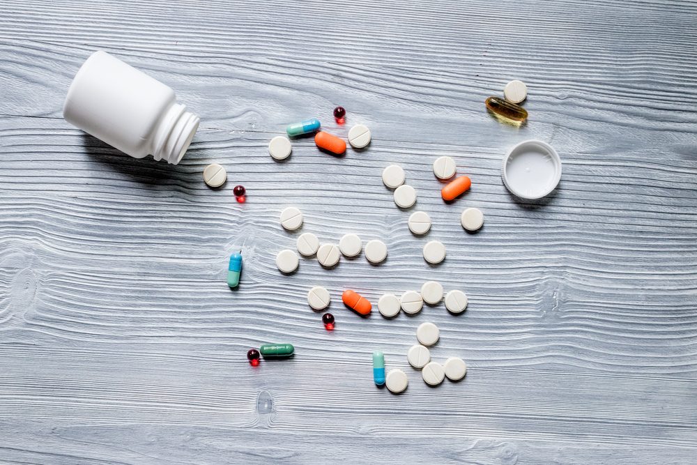 bottle with different pills spilling out