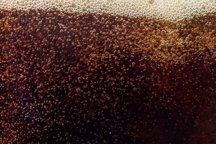 Macro bubble and foam on the glass wall of cola