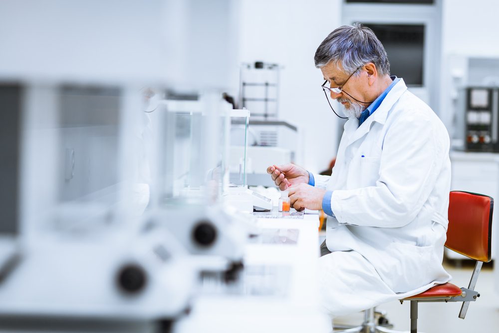 Senior male researcher carrying out scientific research in a lab (shallow DOF; color toned image)