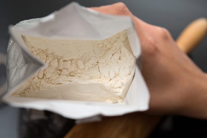 Top View Of Hand Holding Open Bag Of Flour