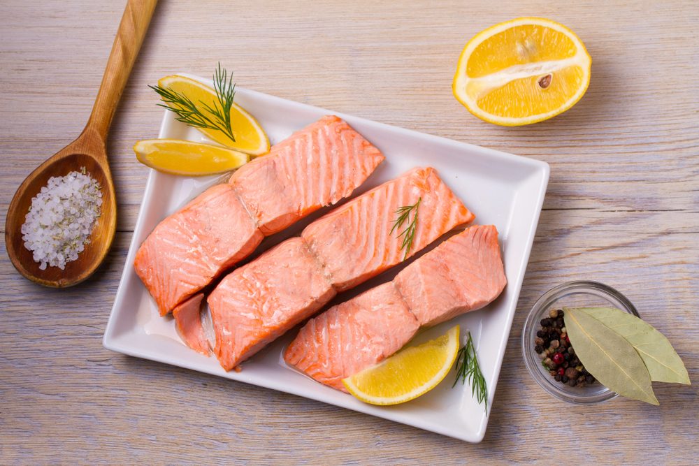 Boiled salmon on white plate. Poached salmon fillet. Good for health diet fish. View from above, top, horizontal