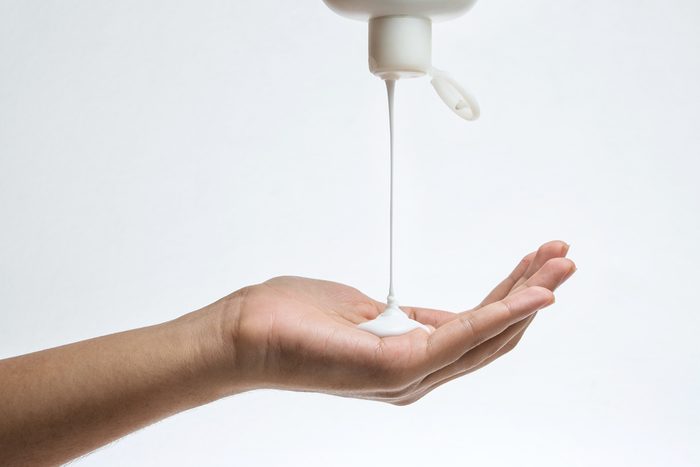 Woman pouring lotion from bottle into her hand