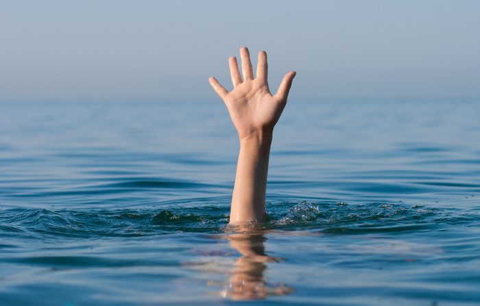 single hand of drowning man in sea asking for help