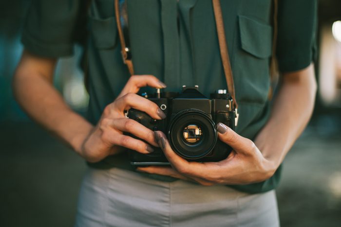 Retro camera photographer close up. Midsection of female photographer
