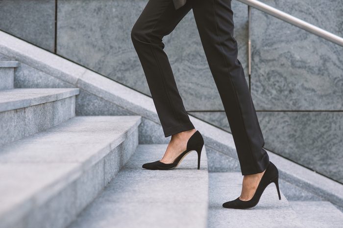 Businesswoman climbing a flight of stairs outdoors.