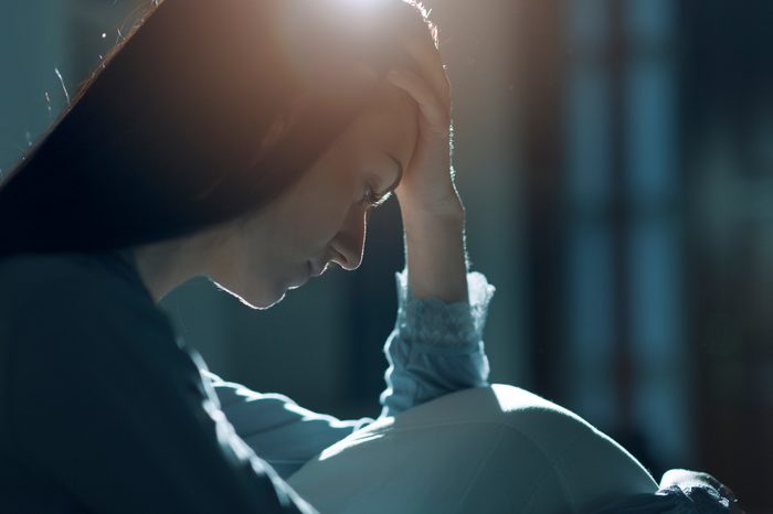 depressed woman hand on head bed night