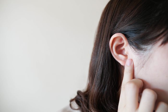woman touching ear ache