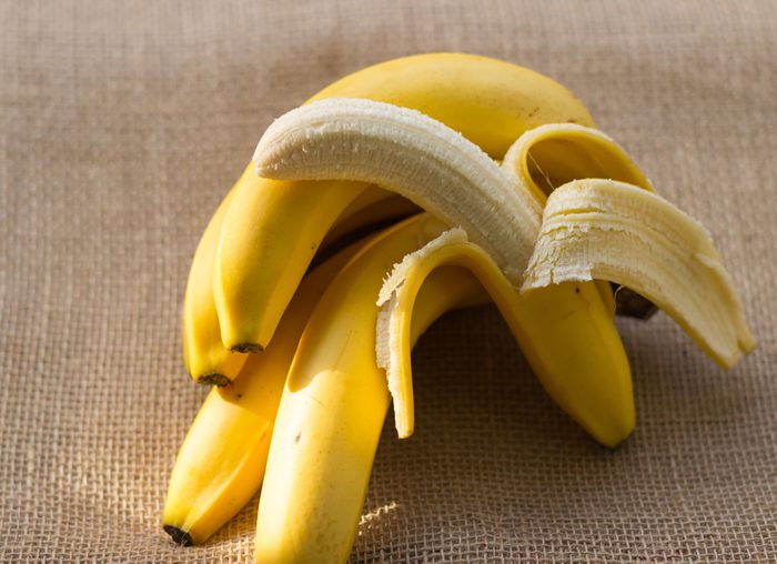 bunch of bananas and one peeled banana