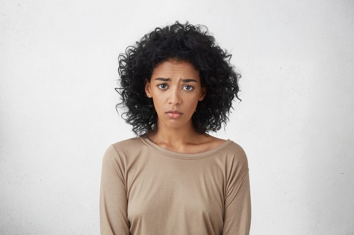 Young woman appears unhappy or regretful.