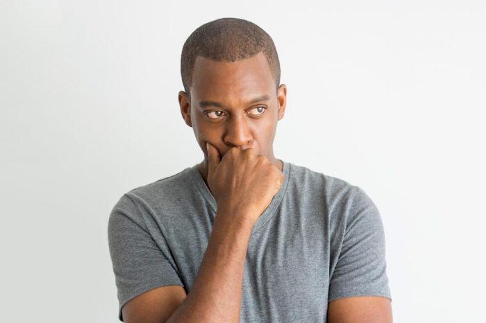Serious introspective guy in t-shirt focusing on problem.