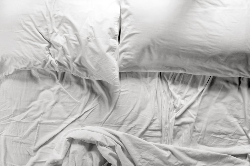 unmade bed and pillows