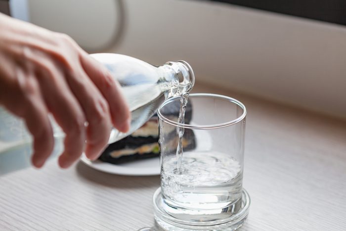 Drinking water is poured from a bottle into a glass.