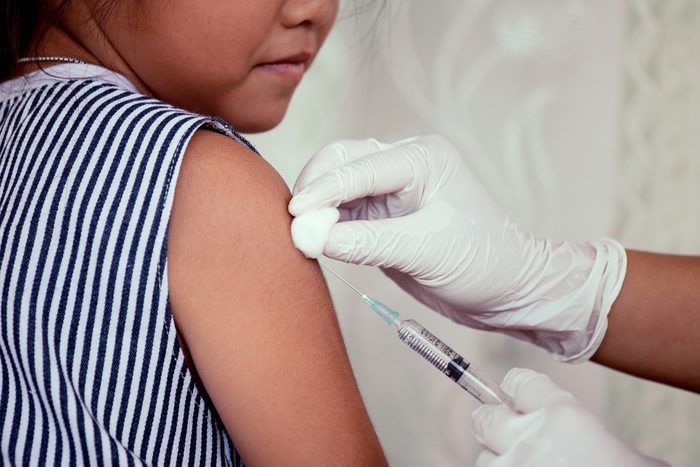 Doctor injecting vaccination in arm of asian little child girl,healthy and medical concept