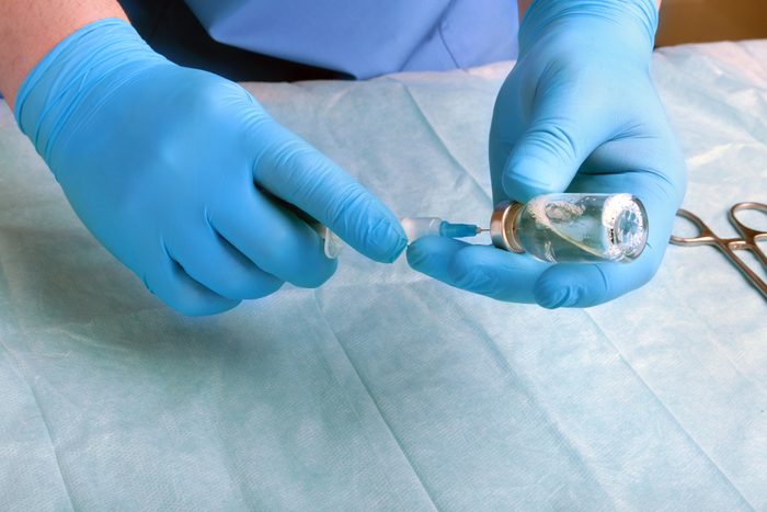 Syringe, medical injection, bottle, ampule in hand, palm or fingers. Medicine plastic vaccination equipment with needle. Nurse or doctor. Liquid drug or narcotic. Health care in hospital.