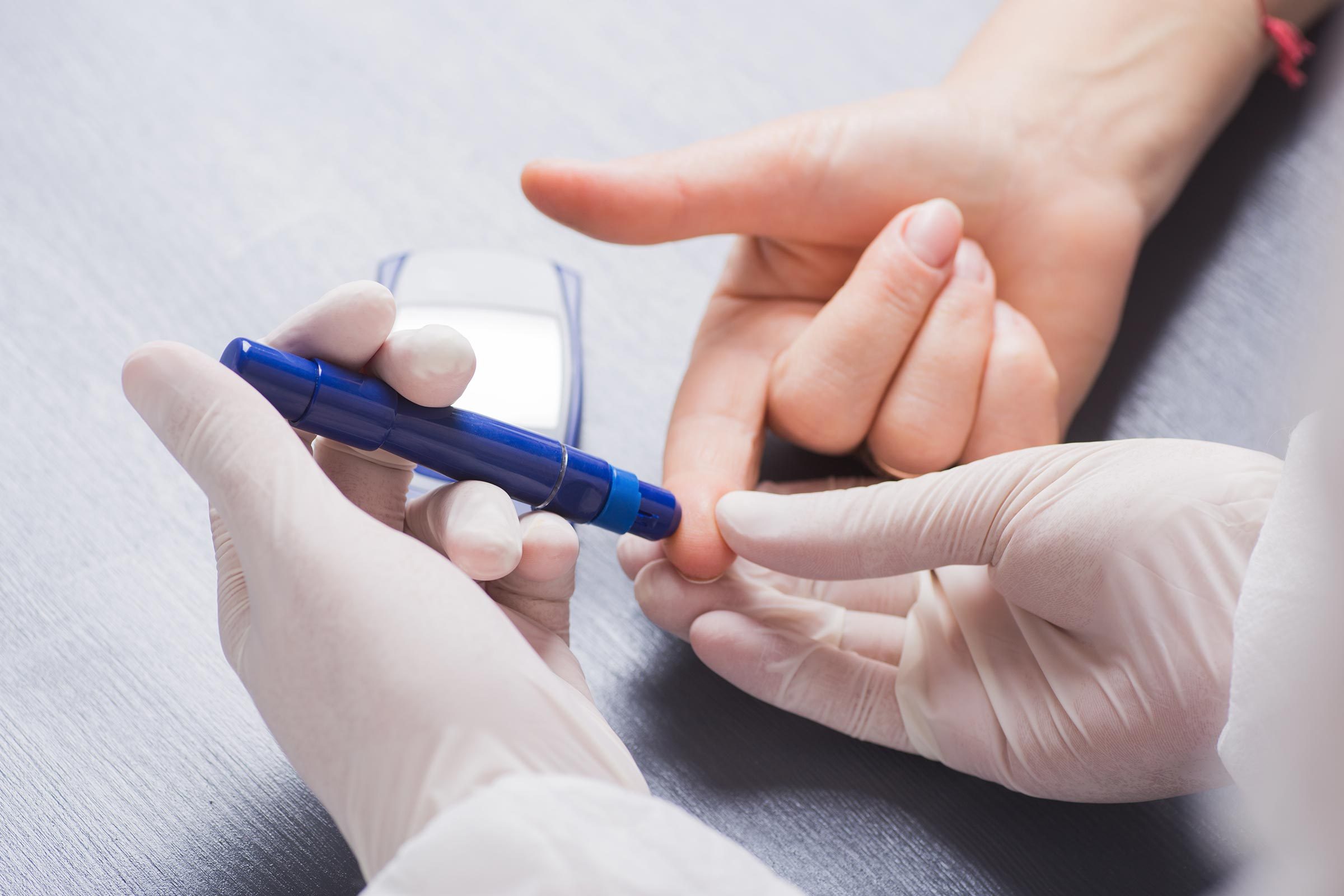 gloved hands administering a needle stick test