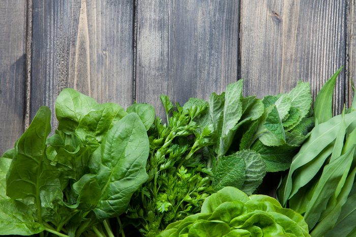 Fresh herbs (dill, parsley, spinach, peppermint, wild garlic) on a wood background. Ð¢op view. Copy space.