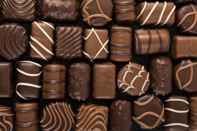 Beautiful Creative Chocolate Sweets on Natural Black Stone Background. Mix of Chocolates Top View and Flat Lay