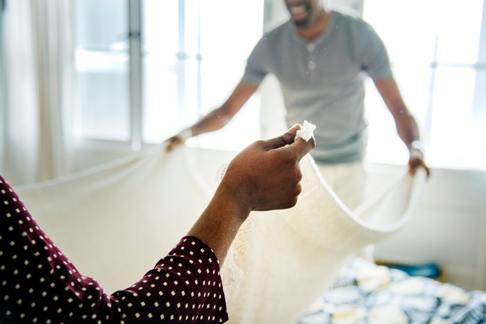 Couple changing a bed sheet together