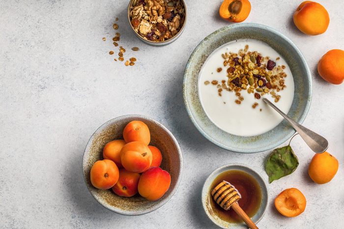Healthy breakfast with yogurt, honey granola, fresh apricots.