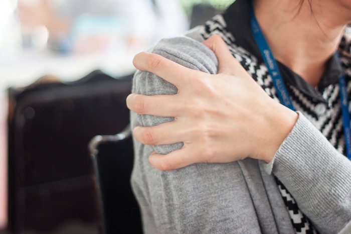 Close up woman with shoulder pain or stiffness