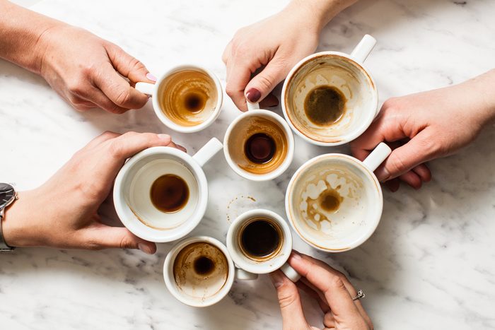 Top view hands holding empty and dirty cups of coffee after party