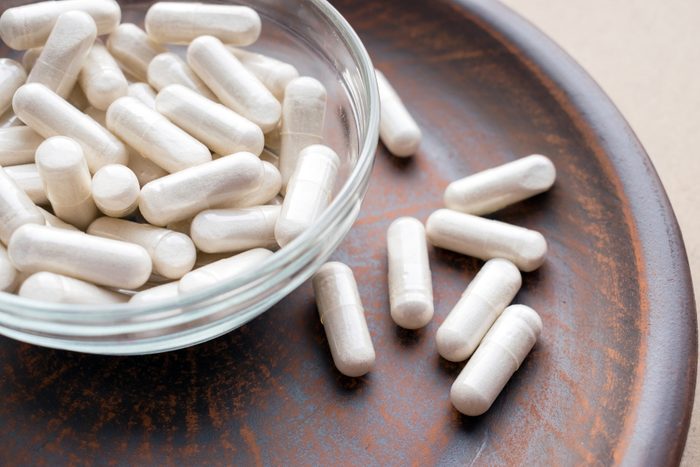 Veg herb capsules on round clay brown plate. Herbal Supplements Dangerous with Prescription Drugs. Dietary supplements, vitamins and minerals for vegans and vegetarians. Healthy lifestyle