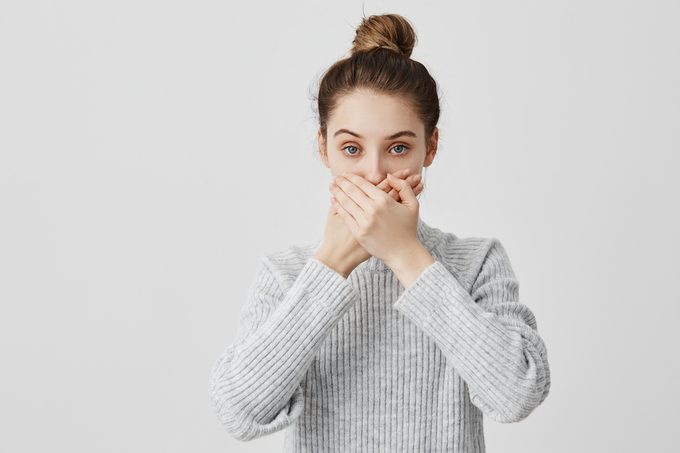 Brunette female 30s covering mouth with both hands keeping silence. Faithful lady friend promising not to tell secrets being trustworthy. People, attitude concept