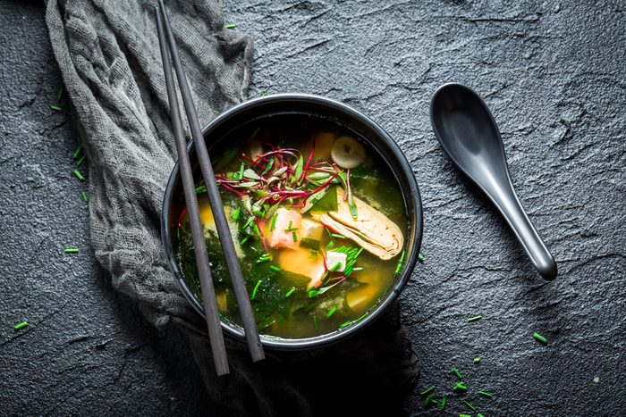 Hot miso soup with salmon in black bowl