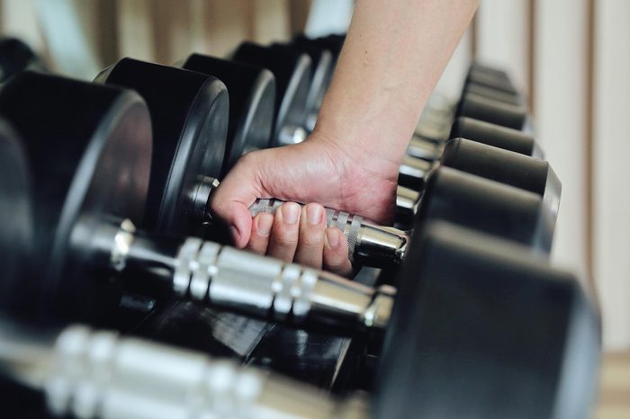 person grabbing a dumbbell