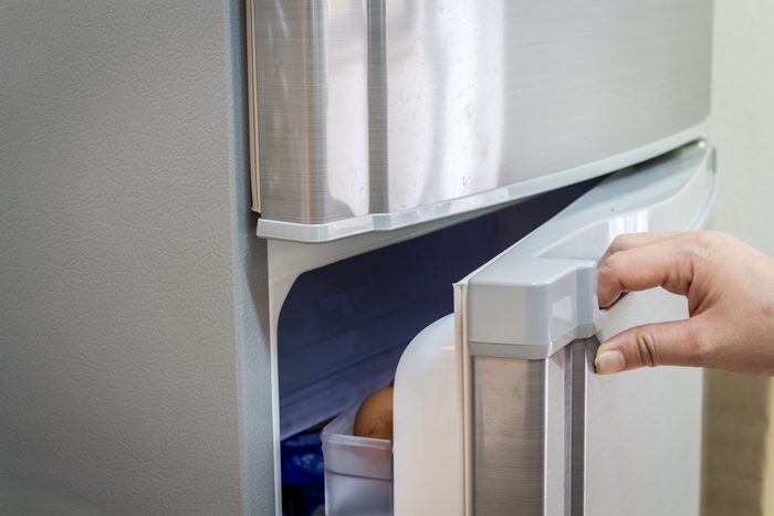 Hand a woman is opening a refrigerator door