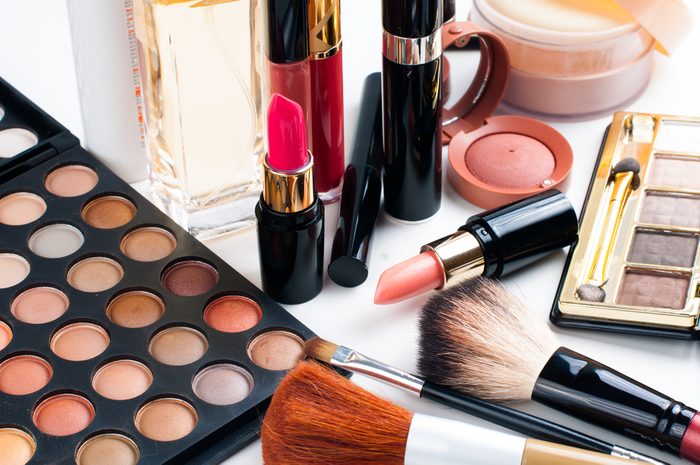 Professional makeup set: eyeshadow palette, lipstick, mascara, blush, powder, make-up brushes and perfume, many cosmetics closeup.