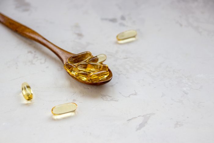 Yellow vitamin capsules, soft gelatin capsule with oily drug and nutritional supplement.