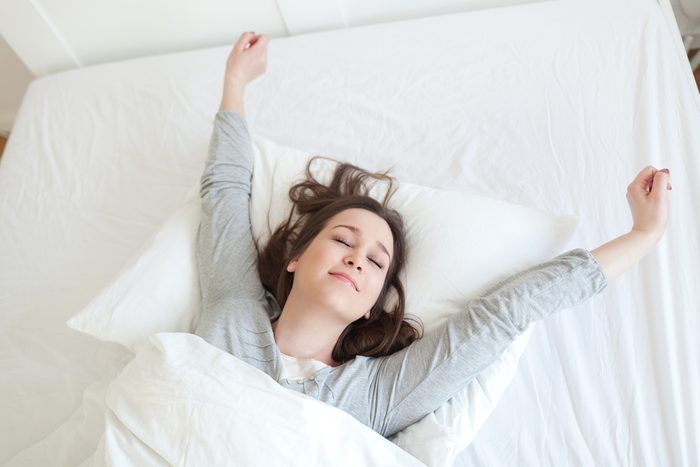 Young beautiful, woman waking up fully rested.