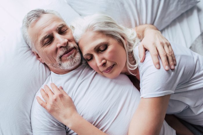Love lives forever! Senior couple at home. Handsome old man and attractive old woman are enjoying spending time together while lying in bed.