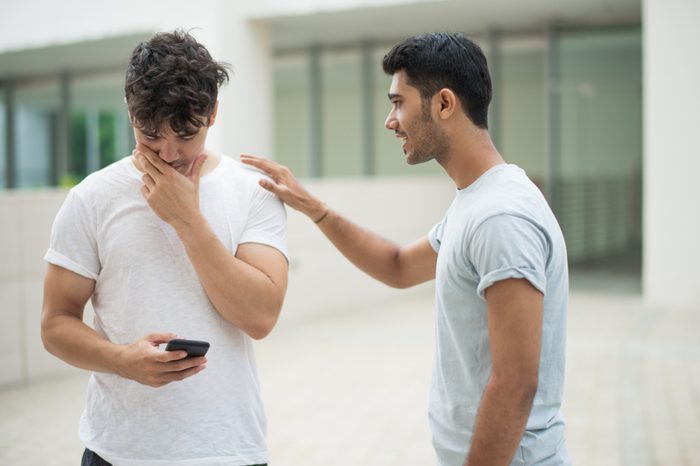Man supporting upset friend 