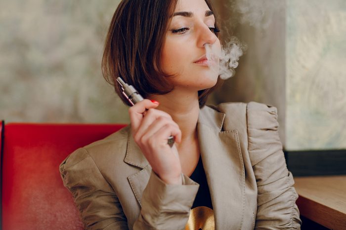 young woman smoking electronic cigarette