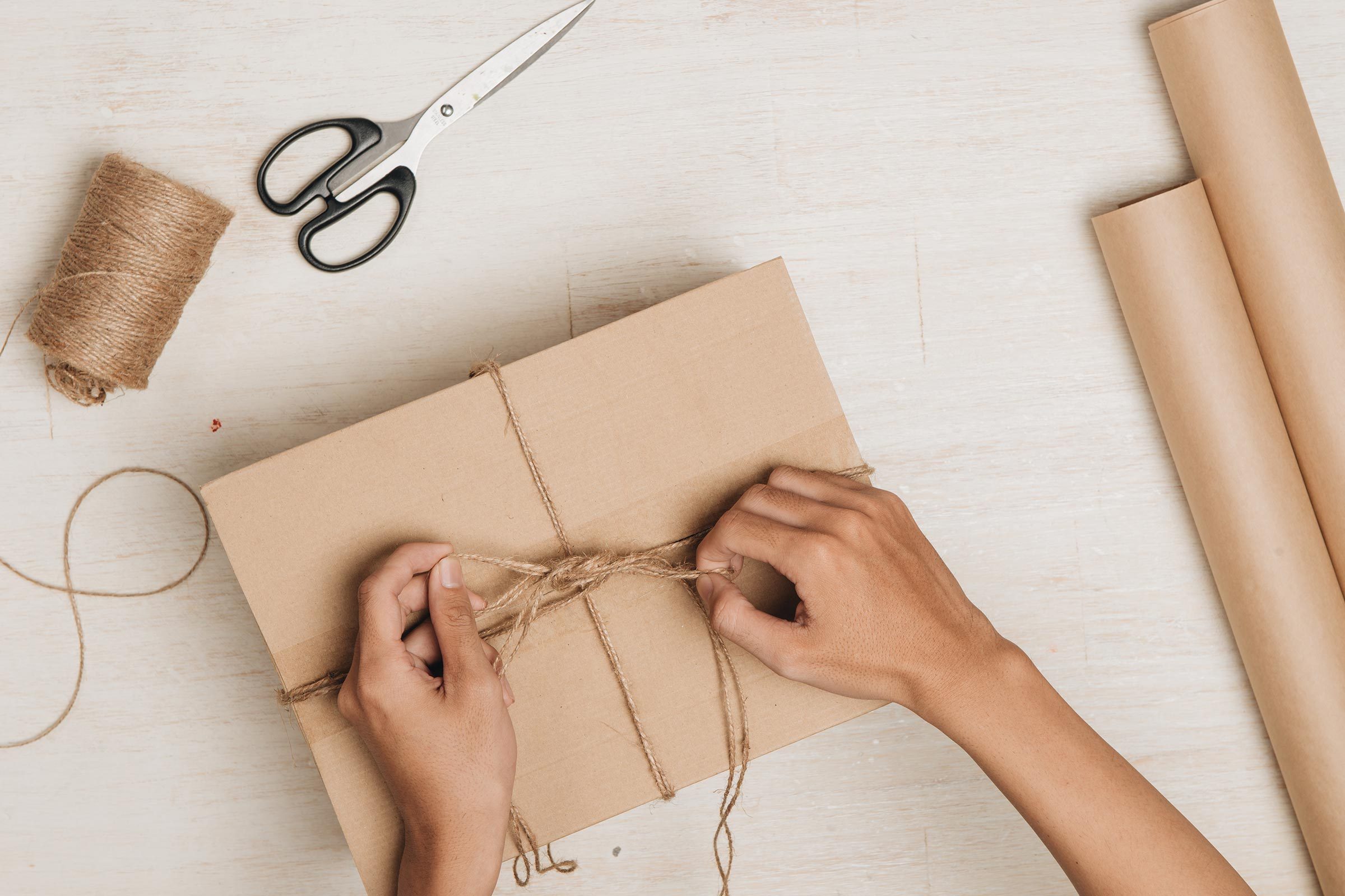 woman tying up a package with string
