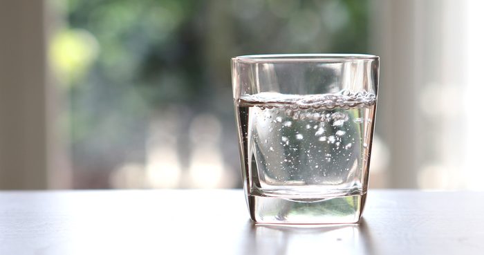 Close up the purified fresh drink water from the bottle on table in living room