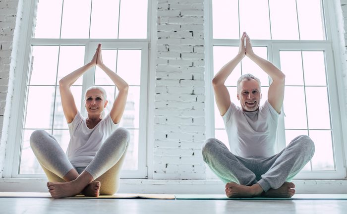 Senior couple is doing fitness training at home. Doing yoga together. Healthy lifestyle concept.