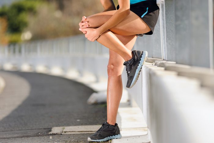 Woman in pain after hurting her leg while running outside.
