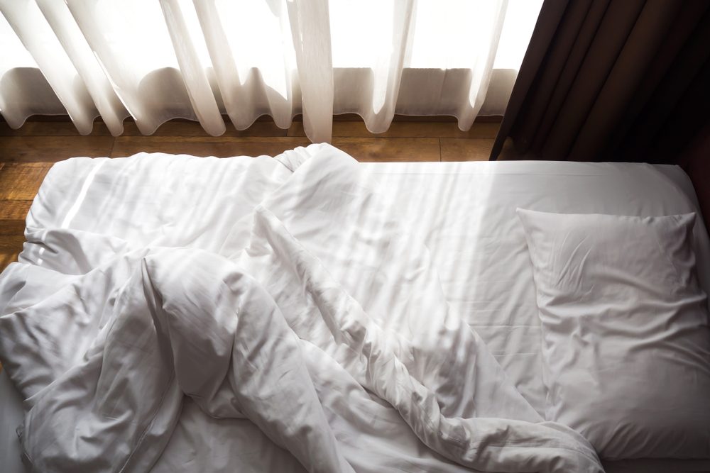 unmade bed with white sheets