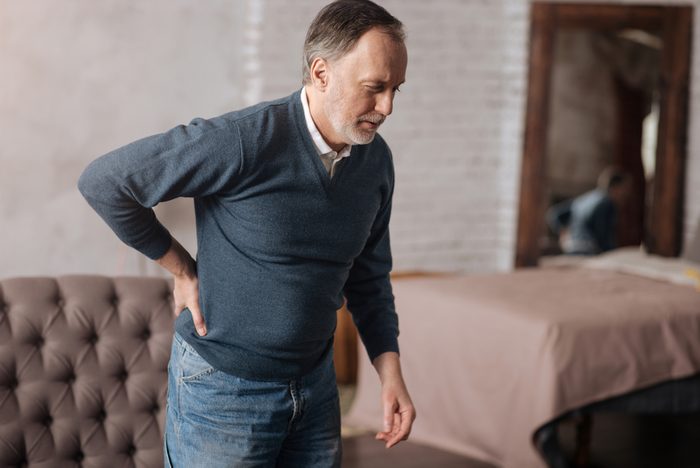 Old man standing with pain in back