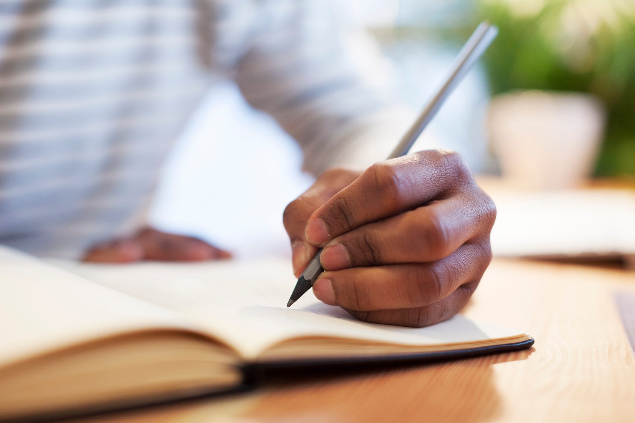 man writing in journal