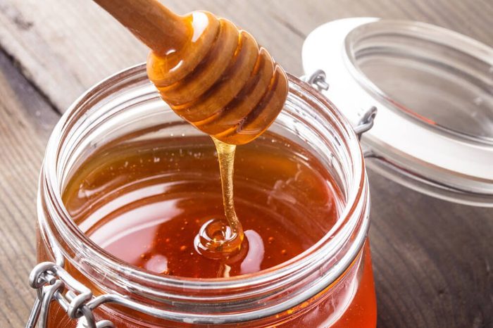 Honey drip in jar on the table