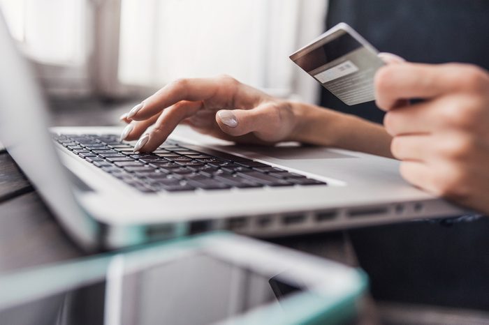 Hand holding credit card and using laptop. Online shopping concept