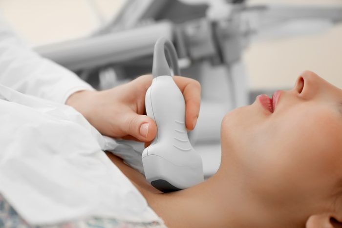 Doctor conducting ultrasound examination of woman in clinic, closeup