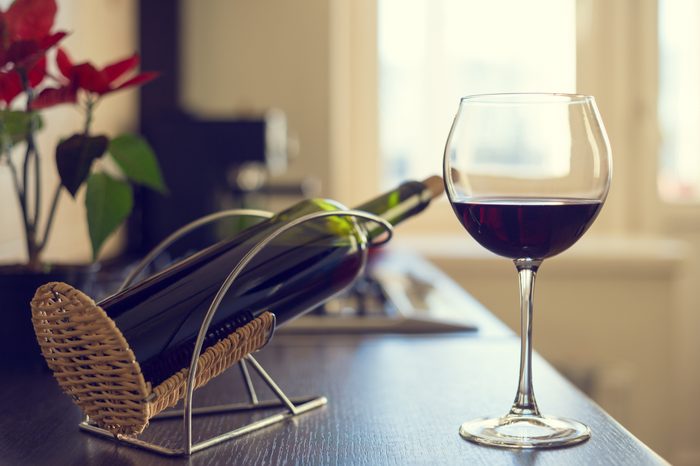 wine bottle and glass of red wine on table at home