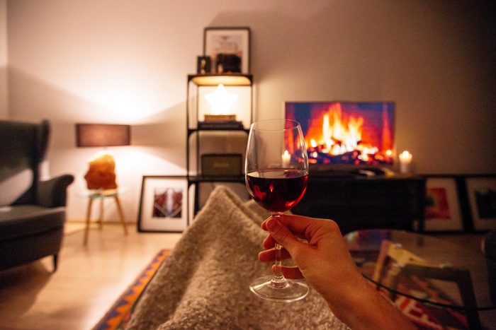 glass of red wine at night while sitting on couch