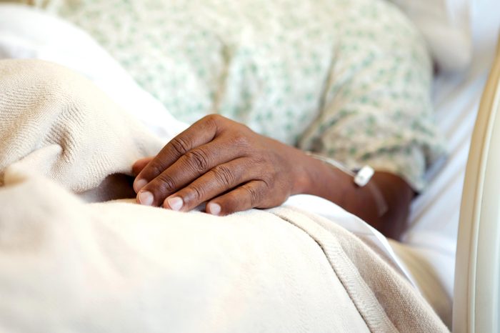 hospital bed hand gown african man