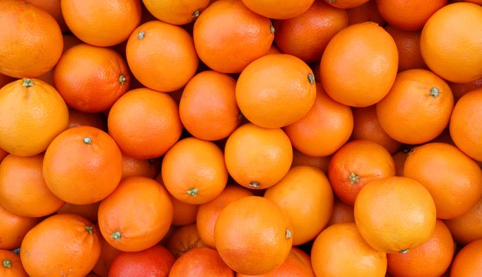 background of juicy ripe oranges freshly picked from the orchard tree